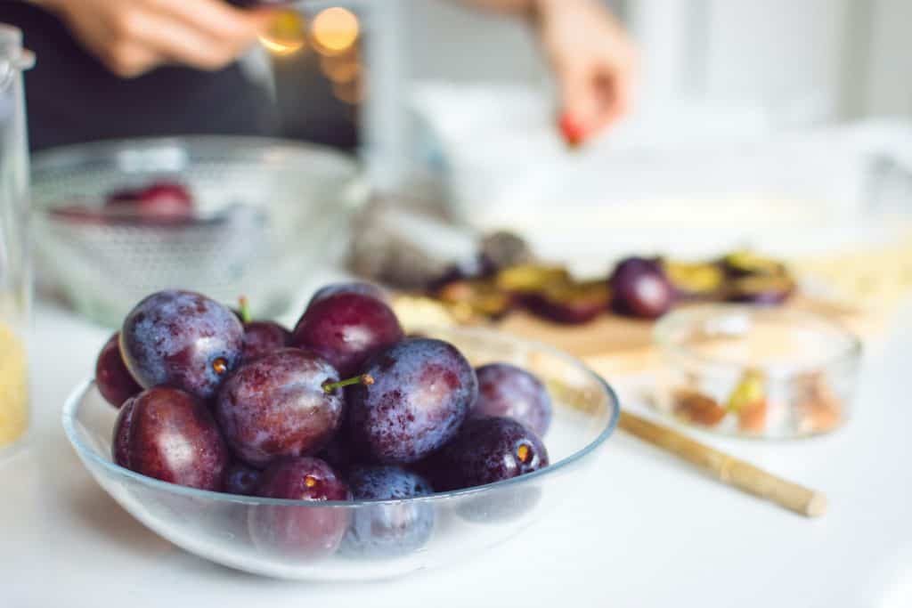 plums in a glass bowl