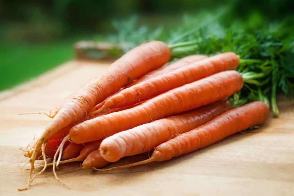 raw carrots on wooden cutting board