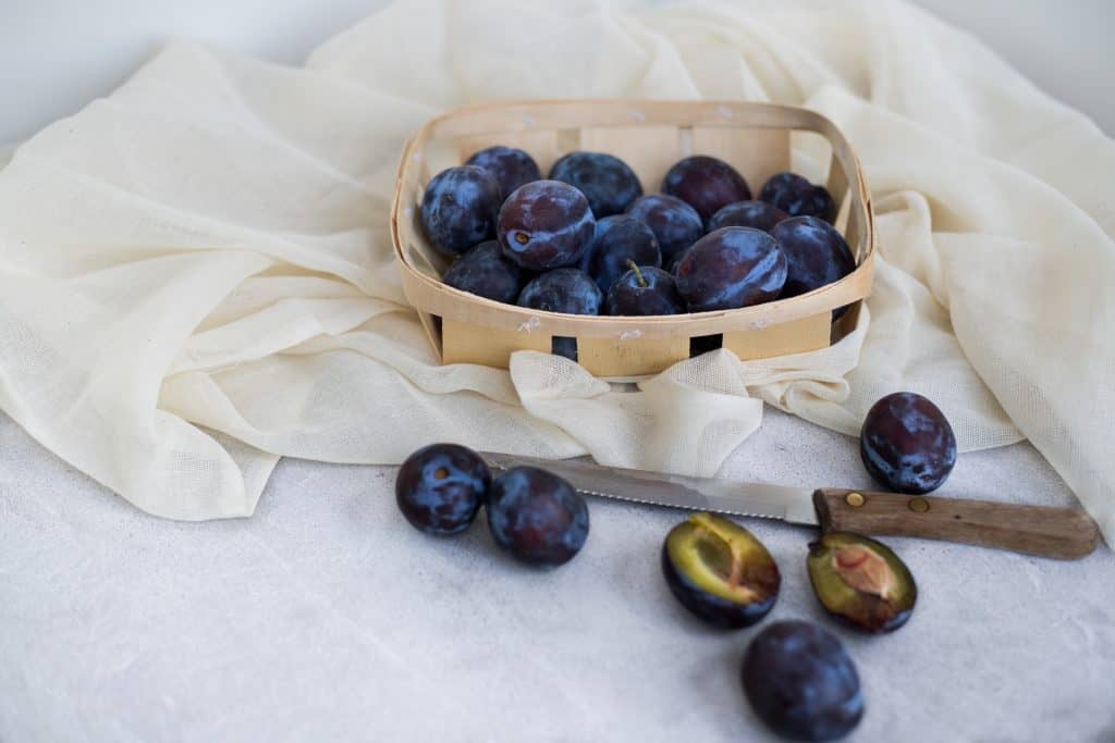 plums in basket with knife
