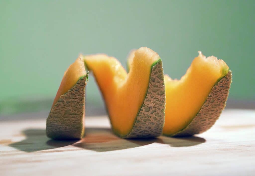 cantaloupe slices on wooden table
