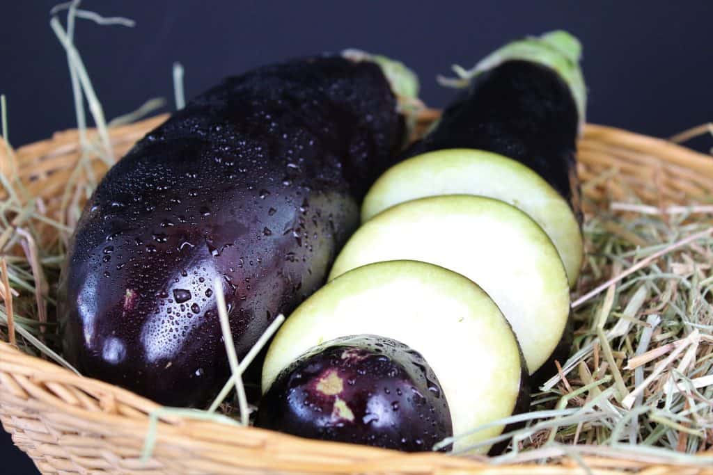 whole eggplant and eggplant slices in basket